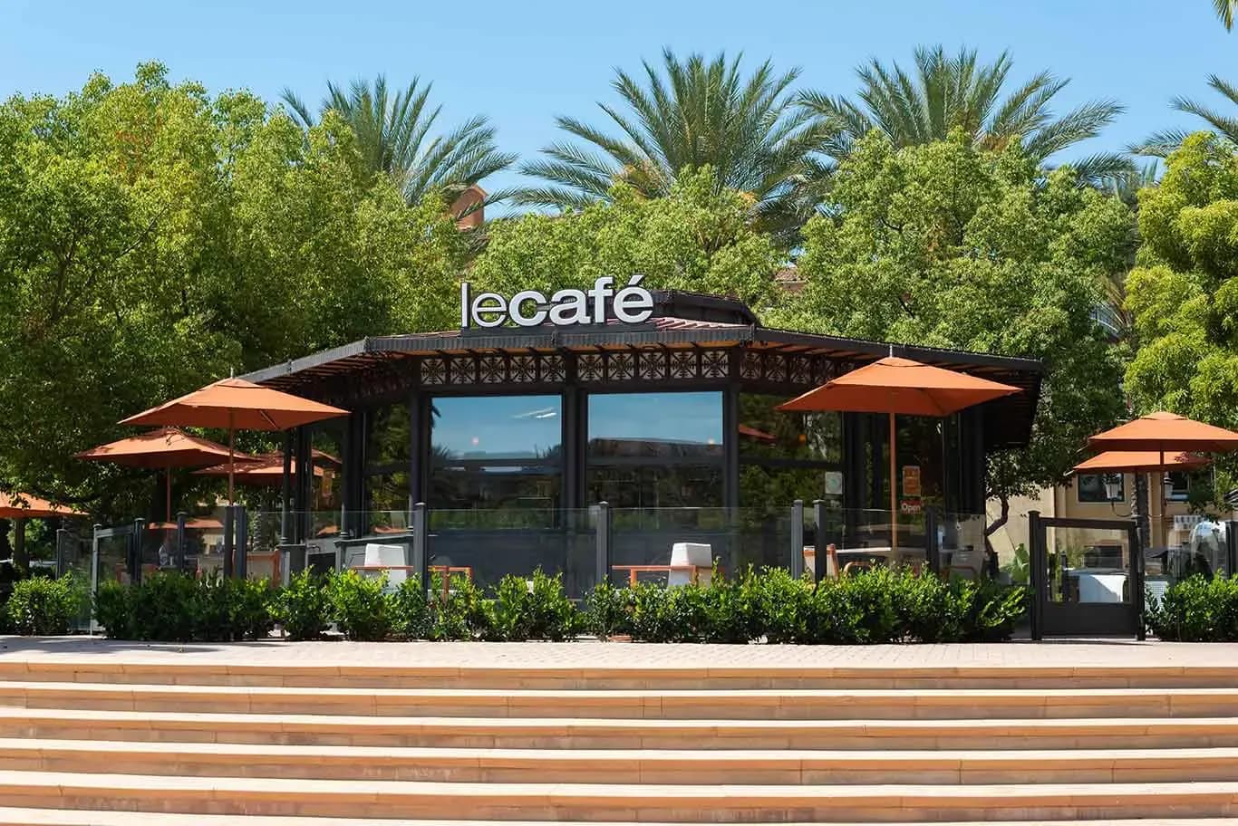 Le Cafe Du Parc, the glass-and-ironwork café kiosk under the palms at The Park at Irvine Spectrum