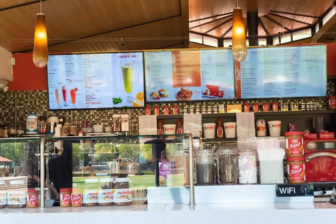 The counter and menu boards inside Le Cafe Du Parc